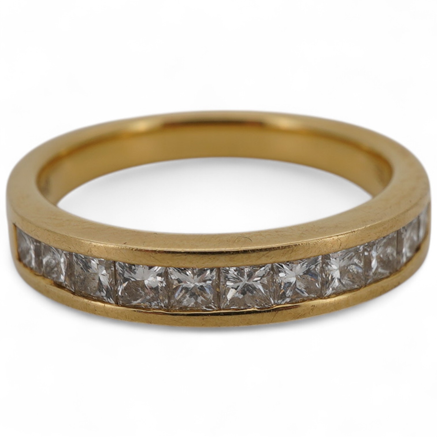 A diamond half hoop ring, channel-set to the front with princess-cut diamonds totalling approximately 0.60 carats, mounted in 18ct gold, size L, British hallmarks, gross weight approximately 4 grams